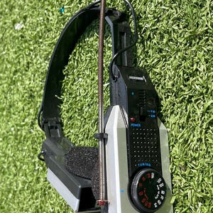 May include: Vintage black and silver AM/FM stereo headphones with a tuning dial and antenna. The headphones have a black headband and ear cushions. The dial is marked with numbers and the words "AM STEREO SOUND".