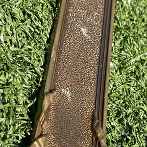 May include: Ornate, rectangular brass door pull with a textured center and decorative floral and scroll accents. The brass has a warm, aged patina, suggesting a vintage or antique style. The door pull is likely for a cabinet or door.