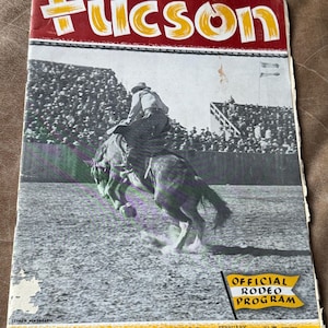 May include: Vintage Tucson rodeo program cover featuring a black and white image of a cowboy riding a bucking horse. The cover has the word "Tucson" in large yellow letters on a red background. The program is titled "La Fiesta de Los Vaqueros" and is dated February 1940.