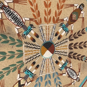 May include: A tan sand painting with a central circular design in black, white, brown, and yellow. The artwork features stylized figures and plant motifs in brown, teal, and white, arranged symmetrically around the center.