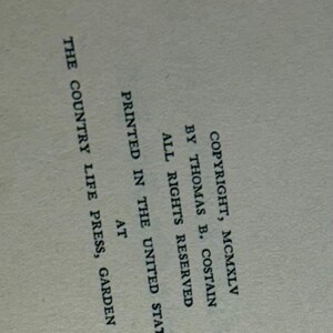 May include: A page from a book with text. The text includes copyright information, author Thomas B. Costain, and the printing location in Garden City, N.Y. The text is in black font on a light beige background.