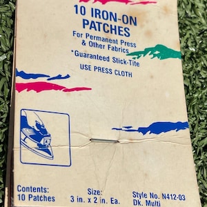 May include: A vintage Penn brand package containing 10 iron-on patches for permanent press and other fabrics. The cardboard header features blue text, a graphic of an iron, and states the size as 3 in. x 2 in. each, style number N412-03.