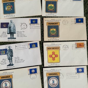 May include: A collection of vintage envelopes featuring state flags and seals, including Wisconsin, Vermont, New Mexico, and Virginia. Each envelope has a commemorative stamp and text related to the Bicentennial.