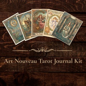 Può includere: Cinque carte dei tarocchi rettangolari con illustrazioni colorate e complesse di figure e simboli, disposte a ventaglio sopra il testo Art Nouveau Tarot Journal Kit, stampato con un carattere serif chiaro su uno sfondo in legno scuro.