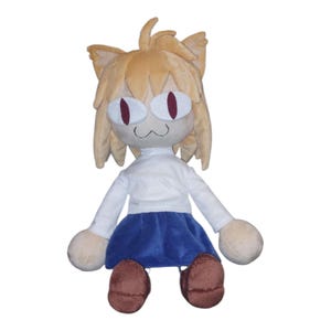 May include: A plush doll featuring a cat-like character with tan fur, large red eyes, and a white shirt and blue skirt. The doll has rounded limbs and brown shoes. The overall design is cartoonish and whimsical.