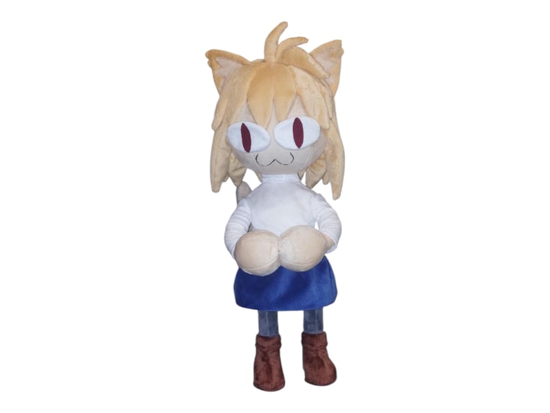 May include: A plush toy of a cat-like character with tan fur, large red eyes, and a white shirt. The character wears a blue skirt and brown boots. The toy has large, rounded paws and cat ears. The plush is standing upright.
