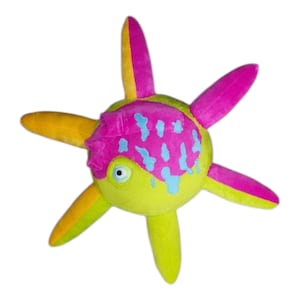 May include: A plush toy in the shape of a sea creature. The toy features a lime green body with yellow and pink appendages. The head is pink with blue accents and a single blue eye. The toy is designed to resemble a sea creature.