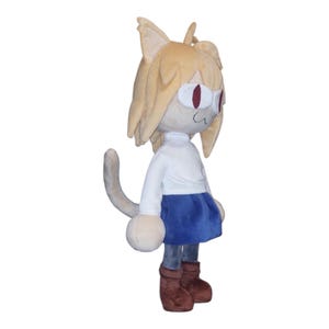 May include: A plush doll of a cat-like character with tan fur, large ears, and red eyes. The doll wears a white shirt, a blue skirt, and brown boots. The tail is gray and curved.