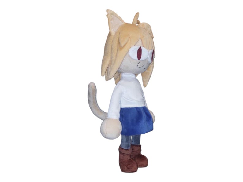May include: A plush doll of a cat-like character with tan fur, large ears, and red eyes. The doll wears a white shirt, a blue skirt, and brown boots. The tail is gray and curved.
