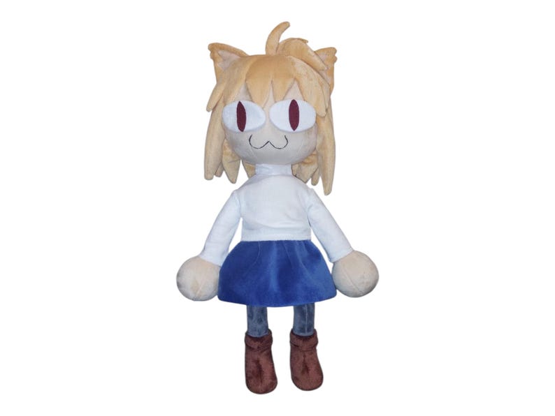 May include: A plush doll of a cat-eared character with a white shirt, blue skirt, and brown boots. The doll has tan fur, large red eyes, and a small, smiling mouth. The doll's arms and legs are rounded.