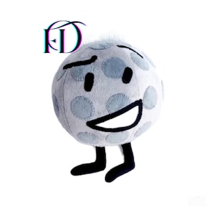 May include: A plush toy resembling a golf ball, featuring a smiling face, black eyes, and black feet. The golf ball is white with light blue spots. The letters "FD" are in the upper left corner.