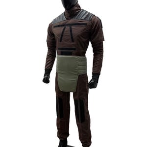 May include: A brown and black costume displayed on a mannequin. The costume features a high collar, shoulder pads, and a green waist belt. The pants have black patches on the knees. The mannequin has a black head and hands.