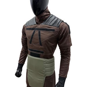 May include: Brown and black costume with a black helmet. The costume features a padded shoulder design, a light green waist protector, and black gloves. The costume has a geometric design on the chest and is made of a durable material.