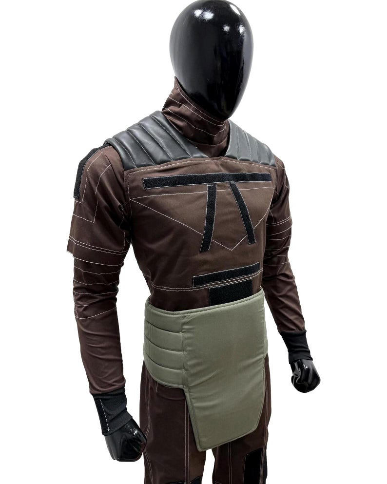 May include: A brown and black costume displayed on a mannequin. The costume features a high collar, shoulder pads, and a chest design. It includes a light green waist protector and black gloves. The mannequin has a black head.