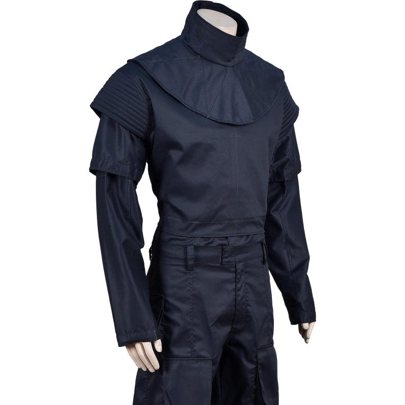 May include: A dark navy blue costume featuring a high collar, shoulder accents, and long sleeves. The outfit includes a matching top and pants, with a structured design and multiple pockets. The fabric appears to be a durable, possibly synthetic material.