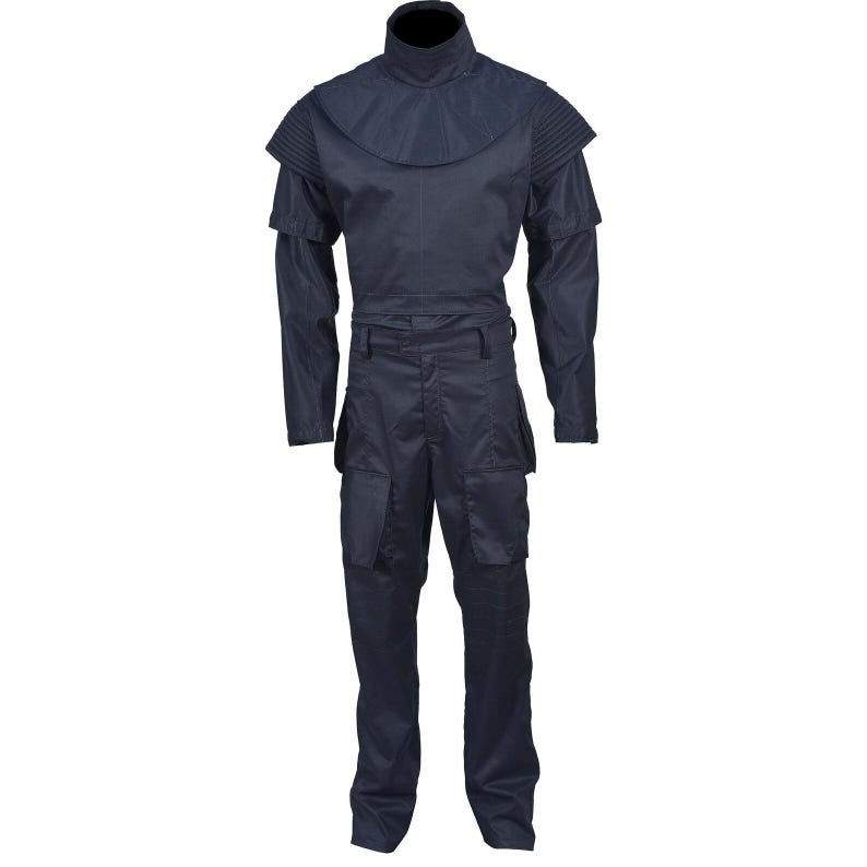 May include: A navy blue jumpsuit with a high collar and shoulder detailing. The one-piece garment features long sleeves, a belted waist, and multiple pockets on the legs. The overall design suggests a futuristic or tactical aesthetic.