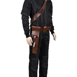 May include: Black jumpsuit with white stitching and a brown leather belt and holster. The outfit includes a shoulder strap with multiple compartments. The mannequin is wearing black boots and gloves.