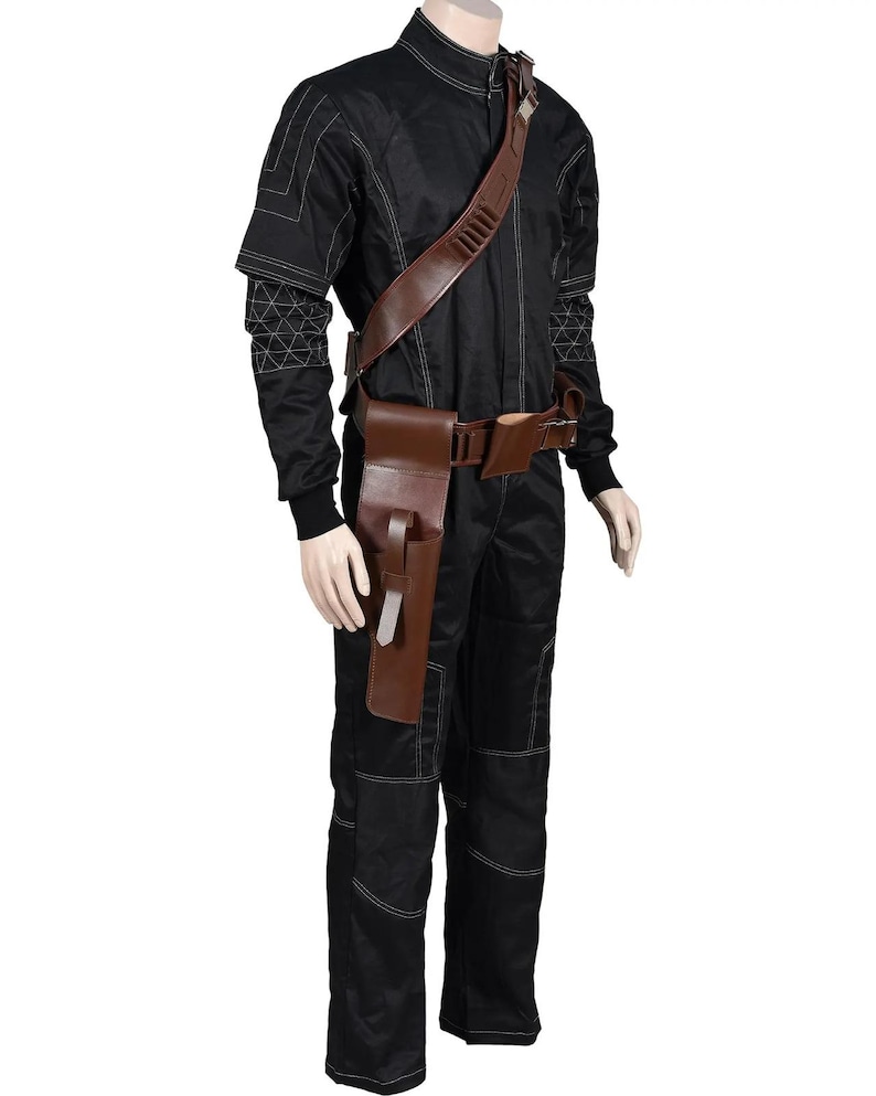 May include: Black jumpsuit with white stitching and a brown leather belt and holster. The outfit includes a shoulder strap with multiple compartments. The mannequin is wearing black boots and gloves.