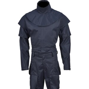 May include: A dark navy blue jumpsuit with a high collar and layered shoulder details. The long-sleeved garment features a cinched waist and multiple pockets on the pants. The overall design suggests a futuristic or military-inspired aesthetic.