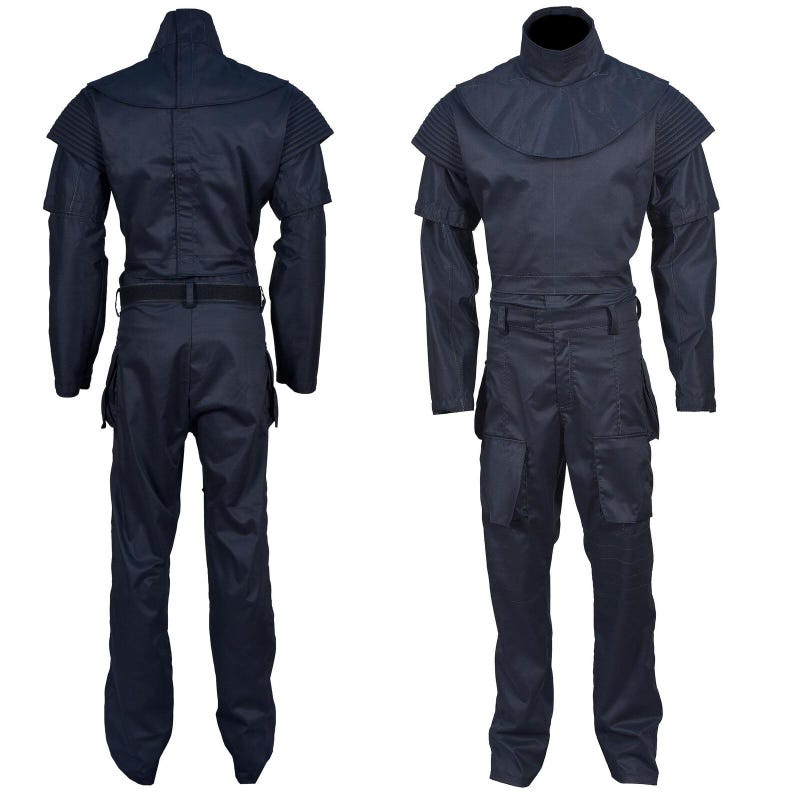 May include: Navy blue jumpsuit with a high collar and shoulder detailing. The one-piece garment features long sleeves, a belt at the waist, and multiple pockets on the legs. The jumpsuit is displayed from the front and back.