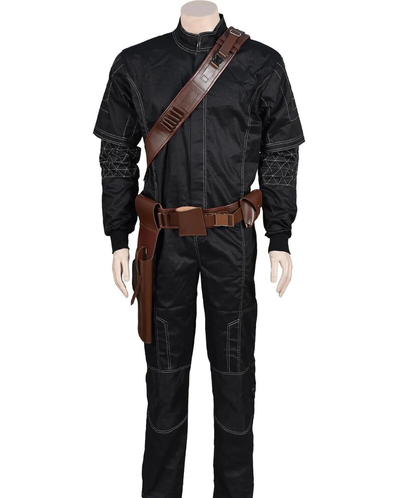 May include: Black jumpsuit with white stitching and brown leather accessories. The costume includes a shoulder strap, belt, and holster. The sleeves have a geometric pattern on the upper arm. The outfit is displayed on a mannequin.