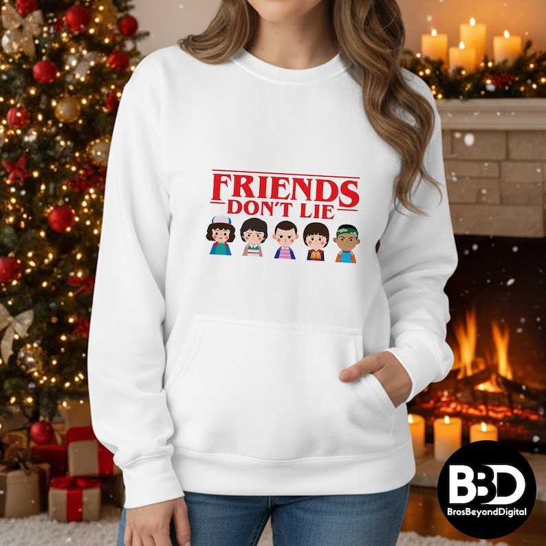 May include: White hoodie with a front pocket, featuring the text "FRIENDS DON'T LIE" in red, above cartoon illustrations of characters. The hoodie is a comfortable, casual garment.