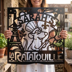 Peut inclure: Une enseigne murale en métal noir avec une découpe représentant un rat portant une toque de chef et tenant une cuillère en bois. Le panneau affiche le texte "SARAH'S" et "RATATOUILLE", ainsi que des silhouettes de la tour Eiffel, un fouet et une tomate.