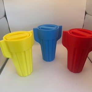 May include: Three brightly coloured plastic wire connectors in yellow, blue, and red. Each has a ridged body and a flat, circular top with a slot. These connectors are designed to twist wires together.