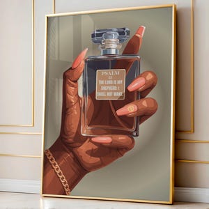 May include: A framed art print featuring a dark-skinned hand holding a perfume bottle. The bottle is rectangular with a clear, faceted top. The text on the bottle reads "Psalm 23: The Lord is my Shepherd; I shall not want." The hand has long, pink nails and a gold bracelet.