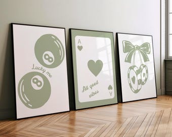 May include: Three framed art prints with a casino theme. The first print features two eight balls with the text "Lucky me". The second print shows an ace of hearts card with the text "All good vibes". The third print has a pair of cherries and casino chips.