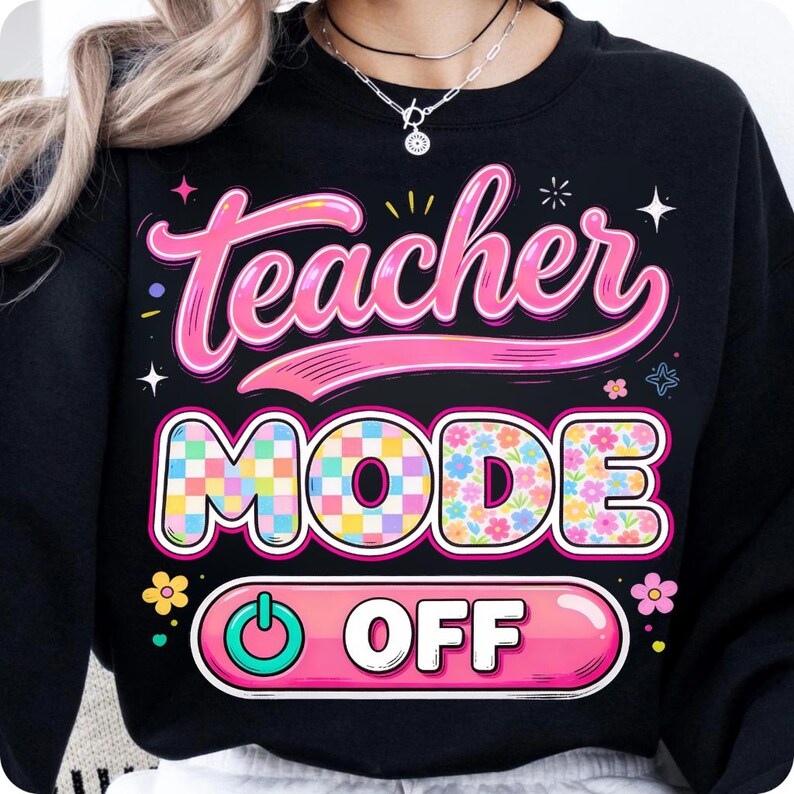 May include: Black sweatshirt with the words "Teacher Mode Off" in a colorful design. The text "Teacher" is in pink script, and "Mode" is in a checkered pattern. The word "Off" is in a pink button design.