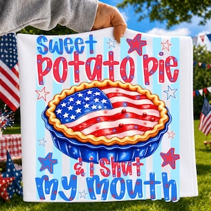 May include: A white kitchen towel featuring a graphic of a pie with a crust shaped like the American flag. The text reads Sweet potato pie & I shut my mouth. The design includes light blue vertical stripes and red and blue stars on a white background.