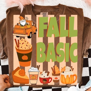 May include: A brown t-shirt featuring a graphic with the text FALL BASIC in green letters. The design includes an orange truck with a gnome, a pumpkin spice latte, a slice of pumpkin pie, and various mugs filled with whipped cream and pumpkins.