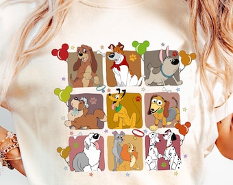 May include: Cream-colored t-shirt featuring a grid of cartoon dog characters, each in a square frame with colorful balloons and stars. The dogs vary in breed and color, with some wearing accessories.