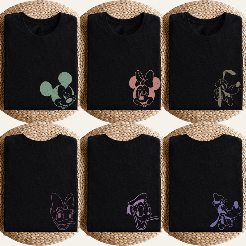 Puede incluir: Seis camisetas negras con diferentes gr&aacute;ficos de personajes de Disney. Los personajes incluyen a Mickey Mouse, Minnie Mouse, Pluto, Daisy y Donald. Los gr&aacute;ficos son en varios colores pastel, y las camisetas est&aacute;n dobladas.