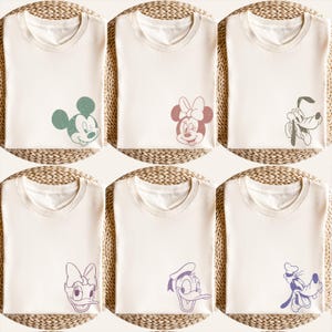 Puede incluir: Seis camisetas de color crema, cada una con un gr&aacute;fico diferente de un personaje de Disney. Los personajes incluyen Mickey Mouse, Minnie Mouse, Pluto, Daisy Duck y Donald Duck. Los gr&aacute;ficos son de colores apagados, lo que a&ntilde;ade un toque vintage.
