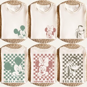 Puede incluir: Camisetas de color crema con los personajes de Disney Mickey Mouse, Minnie Mouse y Pluto Dog. Algunas camisetas tienen gr&aacute;ficos de personajes, mientras que otras tienen el nombre del personaje impreso en un fondo a cuadros. Las camisetas est&aacute;n dobladas.