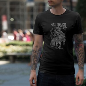 May include: Black t-shirt featuring a detailed white illustration of a mythical creature with multiple heads and a patterned body. The shirt is made of a soft material and is being worn by a person.