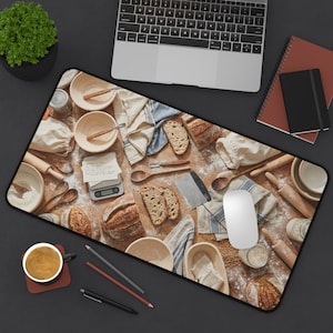 May include: A rectangular mouse pad featuring a bread-making theme. The pad displays various baking tools, ingredients, and freshly baked bread. A laptop, notebook, and coffee cup are also visible.