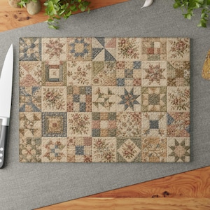Puede incluir: Una tabla de cortar rectangular de vidrio con un diseño de colcha de retazos con varios bloques cuadrados. El patrón incluye estampados florales, formas geométricas y motivos de estrellas en tonos apagados de azul, verde, rosa, beige y crema.