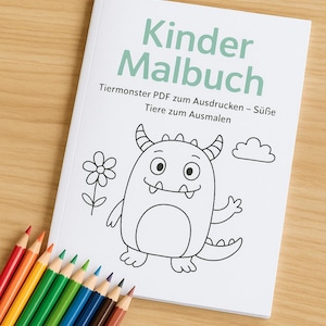 May include: A white coloring book titled "Kinder Malbuch" with a cartoon monster illustration. The book is open, revealing a black and white drawing of a friendly monster. A set of colored pencils in various colors are arranged on a wooden surface.