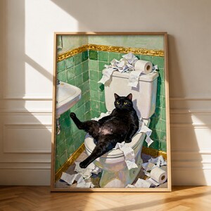 Könnte beinhalten: Ein gerahmter Wandkunstdruck, der eine schwarze Katze auf einer weißen Toilette in einem Badezimmer mit grünen Fliesen zeigt. Die Katze ist von verstreutem weißem Toilettenpapier umgeben, wobei eine Rolle auf dem Spülkasten liegt.