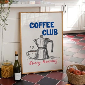 Könnte beinhalten: Ein rechteckiger gerahmter Kunstdruck mit weißem Hintergrund. Der Text COFFEE CLUB ist in Blau und der Text Every Morning in Pink gedruckt. Eine schwarze Strichzeichnung einer Espressokanne und einer Kaffeetasse ist mittig abgebildet.