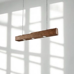 Könnte beinhalten: Eine rustikale, rechteckige Holzleuchte, die an Ketten aufgehängt ist. Der braune Balken hat drei Einbaustrahler. Die Leuchte hängt vor einer weißen Wand mit Schatten.