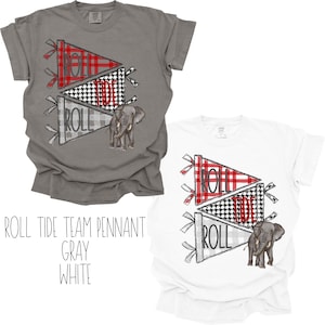 May include: Two t-shirts, one gray and one white, each featuring a pennant design with the word "ROLL" and a plaid pattern. An elephant graphic is also present. The text "ROLL TIDE TEAM PENNANT GRAY WHITE" is below the shirts.
