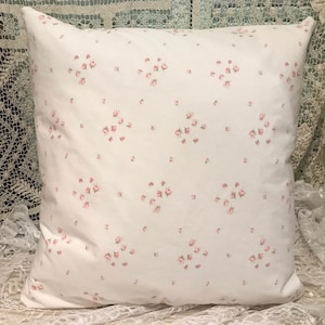 May include: White pillow with a small pink floral pattern.