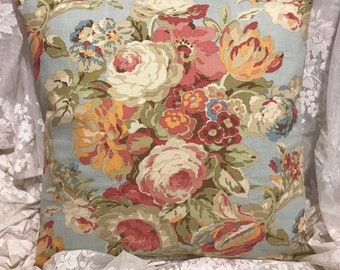 May include: A blue and white floral pillow cover with a large bouquet of pink, red, yellow, and orange flowers. The pillow cover is made of a soft, textured fabric.
