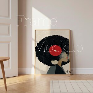 May include: A framed art print featuring a woman's profile with a record design in her hair. The artwork has a black afro, a red record, and a beige background. The frame is a light brown color. The words "Frame Mockup" are written on the image.