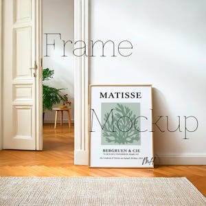 May include: A framed art print featuring a Matisse design with the text "MATISSE" and "BERGRUEN & CIE". The print has a light green background with a coral-like design. The frame is gold-colored, and the image is displayed in a room setting.