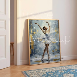 May include: A framed art print featuring a ballerina in a white tutu, arms raised. The painting has a textured, abstract background in shades of blue and gold. The frame is a light wood color.